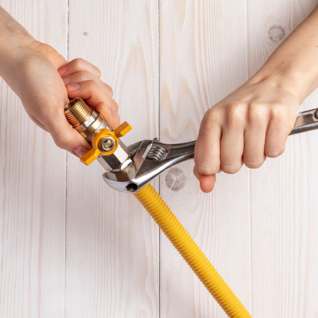 person tightening a gas pipe line