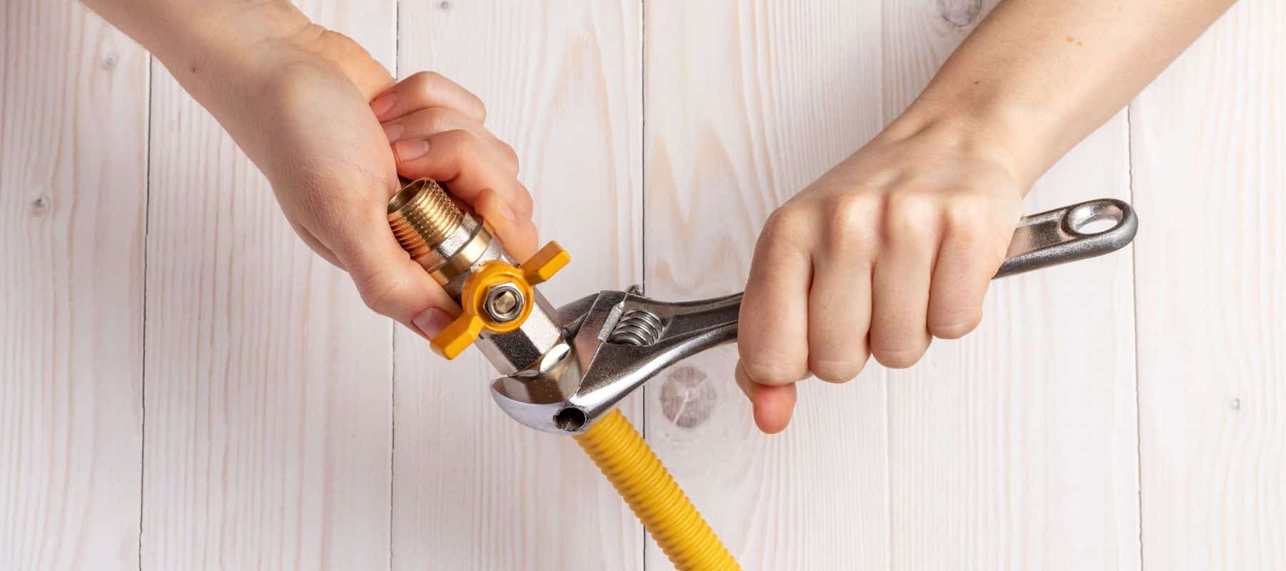 person tightening a gas pipe line